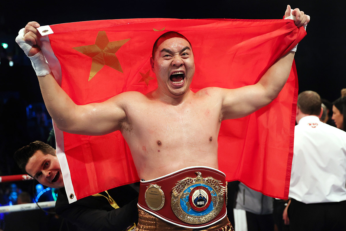 Zhilei Zhang comemora vitória no boxe segurando a bandeira da China.